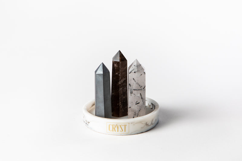 The Concentration and Grounding Trio crystal set including Smoky Quartz, Hematite and Tourmaline Quartz crystals on a CRYST Collective white marble base. These crystals work in synergy to aid concentration, reduce stress and absorb electromagnetic pollution. CRYST Collective interior decor pieces Australia.