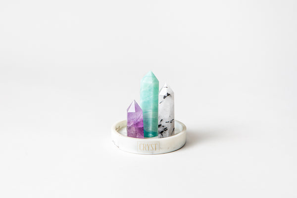 Gemini zodiac sign crystal set including Caribbean Calcite, Amethyst and Tourmaline Quartz authentic crystals, on a CRYST Collective white marble base. Buy crystals online at Cryst Collective.